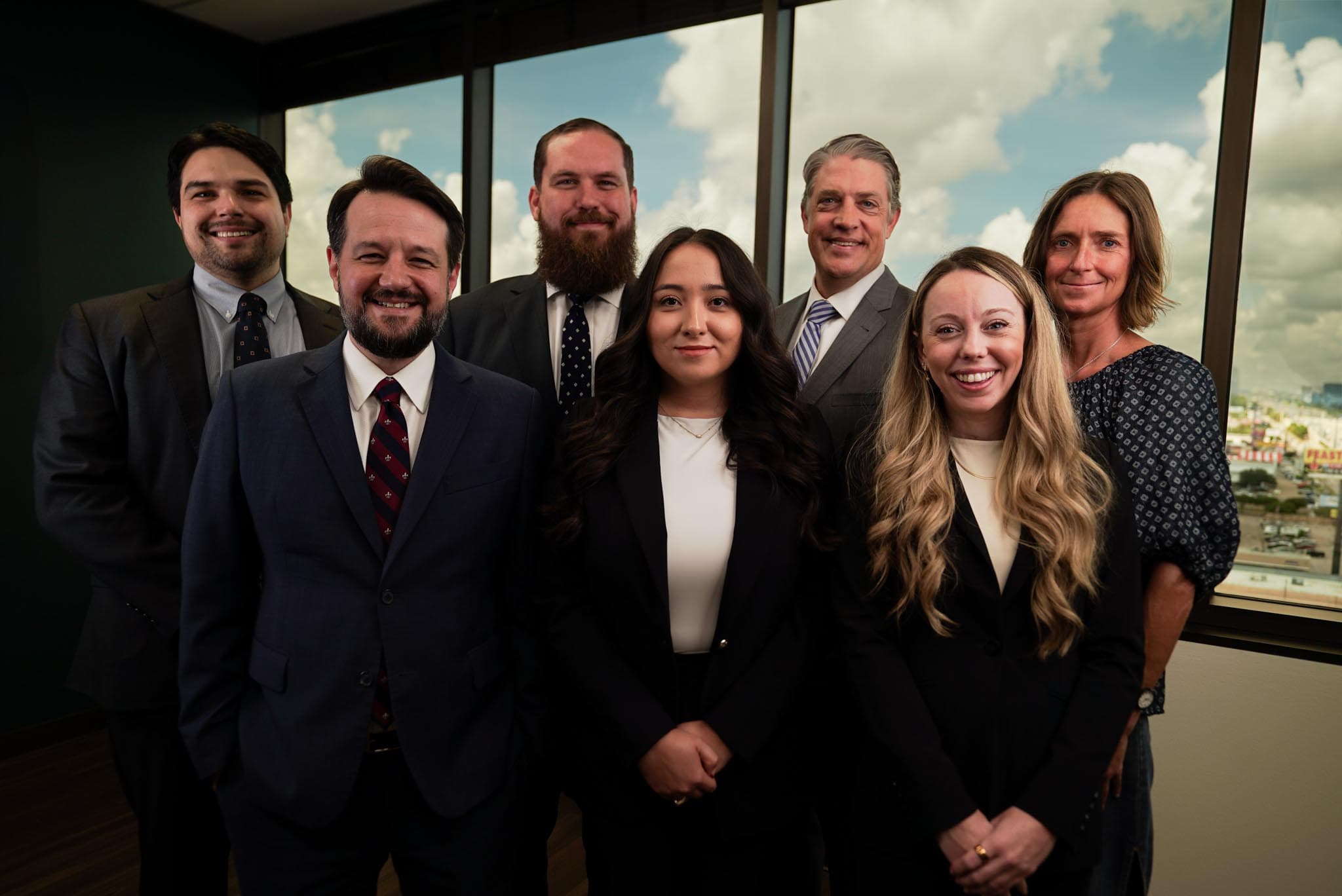 The full Atlas Law Firm team at the office windows.